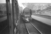 Photograph taken from the window of a train arriving from the north in bay platform 8 at Carlisle station. Stanier Pacific no 46221 <I>Queen Elizabeth</I> is standing at plaform 7. The date is thought to be around 1957, prior to the removal of the station's (by then less than attractive) end screens and the cutting back of the overall roof. <br><br>[Robin Barbour Collection (Courtesy Bruce McCartney) //1957]