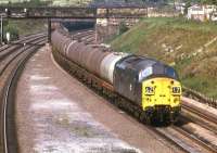 37069 heads an extra eastbound oil train through the cutting <br>
at Horbury Junction on 1 June 1974. The coal train seen disappearing on the left towards Healey Mills was a trip working (8T93) from a local colliery headed by 37251. At that time there was still continuous quadruple track between Heaton Lodge and Wakefield Kirkgate, which was well justified especially east of Healey Mills Yard. Even on this occasion, a Saturday morning, nine loco hauled workings passed in about 75 minutes.<br><br>[Bill Jamieson 01/06/1974]