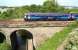 A westbound train on the Edinburgh - Glasgow Central via Shotts route is about to cross the Water of Leith on Slateford Viaduct in June 2010.<br><br>[John Furnevel /06/2010]