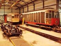Every passenger carrying vehicle on the Manx Electric Railway is over 100 years old. This picture, taken in the workshop building, gives an illustration of some of the ongoing work required to maintain such an old fleet. The bogies in the foreground have just been fitted with refurbished traction motors and will now be refitted to a tramcar who's bodywork has been restored in the main running shed.  Alongside is a trailer car that has had a large amount of woodwork renewed. Car 29, a <I>toastrack</I> with ratchet brakes only, is stored unserviceable and is a long term restoration candidate. Note the unlined inspection pit. Picture taken with kind permission of MER engineering staff.<br><br>[Mark Bartlett 08/10/2010]