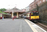 Trains on the Cathcart Circle meet at Queens Park in July 2005. View south east towards Victoria Road with the tenements of Torrisdale Street standing above the station on the right.  <br><br>[John Furnevel 03/07/2005]