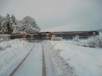 A northbound DMU hurries through Whitemoss Level Crossing, north of Auchterarder, on 1 December scattering snow. On several occasions the klaxons sounded and the barriers came down but no train materialised.<br><br>[John Robin 01/12/2010]