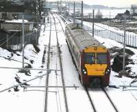 The 12.40 Helensburgh Central - Edinburgh Waverley runs east past the former Forrestfield station on 14 December 2010. Hillend reservoir can be seen in the right background with the town of Caldercruix beyond. <br><br>[John Furnevel 14/12/2010]