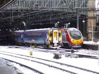 A snow covered Class 156 draws into Platform 3 of Glasgow Central on 6th December, passing 390018 waiting to depart for London Euston. Most services that day were problematic at best due to the heavy snow, with many running late or, in some cases, not at all.<br><br>[Graham Morgan 06/12/2010]