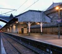 A pre-dawn look along the former 'Sub' Platforms 8 and 9 on 15 <br>
January 2011. The awning is looking a bit tired; it is destined to be replaced in the Waverley station improvement programme, though the Victorian ironwork will be retained. Waverley is one of only 7 stations outside London owned by Network Rail (as is Glasgow Central) and so has NR signage. Waverley's symbol is a castellated letter E, but it's bell shape makes it look rather like a pound sign. I'm sure this wasn't the intention, though I like a '' as much as the next miser.<br>
<br><br>[David Panton 15/01/2011]