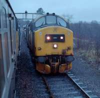 A southbound 37419 (left) draws into Lairg past 37418 'An Comunn Gaidhealach' (right). 37418 can now be found on the East Lancashire Railway while 37419 is in storage at Toton.<br><br>[Ewan Crawford 04/01/1989]