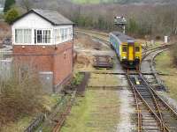 150242 about to relinquish token as it runs into Tondu station from Maesteg on 16 February 2011. The unit will leave as the 13.07 service to Cardiff Central. The mothballed Ogmore Vale line runs off to the right of the DMU, and the sparsely used freight line to Margam is seen joining the operational line in the centre right foreground. There is apparently a proposal (late 2011) to operate a 30min frequency service to Maesteg, as on other lines, and this will no doubt make use of the loop line seen behind the DMU to cross services on the otherwise single track route from Bridgend to Maesteg.<br><br>[David Pesterfield 16/02/2011]