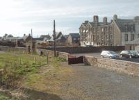 The site of Machrihanish station, terminus of the narrow gauge railway. The line closed in 1931 but there has been very little development on most of the site although some housing has encroached at the west end. However, early photos show there was very little infrastructure at the station and so little remains to indicate what was once here. The hotel, seen here undergoing refurbishment, predated the railway and has long outlived it. [See image 33498] for a map showing the station and surrounding area in 1921.<br><br>[Mark Bartlett 26/03/2011]