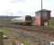 Having almost completed the climb up from the tunnel under the Forth and Clyde Canal, a train from Glasgow Queen Street for Dunblane is about to pass Larbert Junction signal box in April 2006.<br><br>[John Furnevel 26/04/2006]