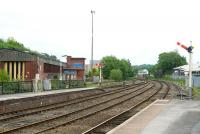 A view of outer station area at Buxton on 4 June 2011. The former BR Buxton diesel depot stands on the left. In the distance is Buxton No 1 Junction signal Box, controlling the station and the line from Stockport. The box also controls two freight lines that come in just out of shot beyond the building on the right and pass by on either side. One of these is the line from Hindlow and the other from Great Rocks/Tunstead.<br>
<br><br>[Peter Todd 04/06/2011]