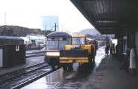 The <I>'Devon Belle'</I> observation car can be glimpsed behind a strange piece of BR platform equipment at Kyle of Lochalsh on a dreich October day in 1966. The tractor was used to shunt fish vans on the quayside and the planking was to cushion the buffers. [With thanks to Adrian Morgan]<br><br>[Frank Spaven Collection (Courtesy David Spaven) /10/1966]
