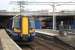 380010 at Platform 4 of Paisley Gilmour Street with a service for Ayr, while 334017 peeks out from behind the protective screening at Platform 1 as it waits to depart for Glasgow Central.<br><br>[Graham Morgan 11/05/2011]