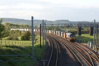 A southbound DRS container train waits in the Eden Valley loop just <br>
south of Penrith on the evening of 30 May 2011. This was the point at which the NER line to Appleby and Kirkby Stephen left the WCML and headed east. A short distance away behind the camera is the site of the former Clifton and Lowther station. <br>
<br><br>[John McIntyre 30/05/2011]