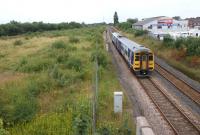 A York - Blackpool service passes the site of the former Lostock <br>
Hall station on 3 August 2011. In the wasteland to the left stood Lostock Hall shed. Some clues still remain from the concrete between <br>
each road and even the odd bit of rail in the long grass. The photograph was taken from Watkin Lane looking west, with the present day Lostock Hall station behind the camera.<br>
<br><br>[John McIntyre 03/08/2011]