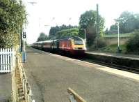 A Virgin HST runs south west at speed through Kirknewton station in September 2002, its engine noise almost drowning out the warning klaxon from the level crossing off picture to the right.<br><br>[John Furnevel 03/09/2002]