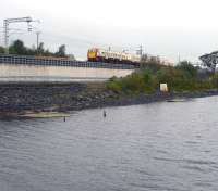 The 12.27 Milngavie - Edinburgh Waverley service approaching Forrestfield through the rain on 19 September 2011. The train is running alongside the east end of Hillend reservoir and will shortly pass the highest point on the line at Holmes Summit [see image 35721].  <br><br>[John Furnevel 19/09/2011]