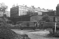 An NBL diesel shunter and brake van at Scotland Street coal depot in mid-1966, a year before closure. The impressive mass of the New Town's Scotland Street dominates the view to the rear, while immediately to the left of the brake van is the bricked-up tunnel which led up the hill to Canal Street station (adjacent, and at right angles to, Waverley). This cable haulage route opened in 1847, and from 1850 to 1868 (when the better graded route via Abbeyhill and Leith Walk stations opened) carried passengers bound for the World's first train ferry, from Granton to Burntisland.<br>
<br><br>[David Spaven //1966]