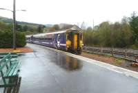 A train from Glasgow Queen Street runs into a wet Crianlarich station on 4 October 2011. The disused timber loading sidings stand in the background. A study is currently underway into the feasibility of reinstating timber loading facilities at Crianlarich, either from an upgraded railhead here, or on the truncated line to the former Crianlarich Lower.  [See image 8732] <br>
<br><br>[Bruce McCartney 04/10/2011]