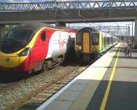 The Pendolino, the 350, and the three young ladies appear to be competing as to who can be most colourful. View South along platform 5 at Milton Keynes Central on 2 September 2011.<br><br>[Ken Strachan 02/09/2011]