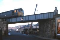 View north along Lower Kessock Street in the Merkinch district of Inverness in 1977 as a class 26  is about to cross with a train from the north. Preparatory work in connection with the replacement of the bridge deck  is taking place in the background. [With thanks to all who responded to this query]<br>
<br><br>[Frank Spaven Collection (Courtesy David Spaven) //1977]