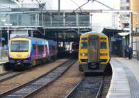 A First TransPennine class 170 unit bound for Hull arrives at Leeds on 4 November 2011, while a Northern service to Sheffield waits in the bay platform on the right, formed by a two car Class 158 unit.<br><br>[John McIntyre 04/11/2011]
