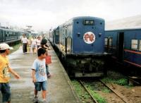 A Hitachi-built BoBo diesel has just arrived at Manila's Tutuban terminus with a passenger train. The single cab engine will reverse smartly out of the platform to shunt around the stock, ready for the next duty. Notice the signalling tower and shed in the left background, and the pitched roof on the carriage to the right - to stop passengers getting free rides atop the coach. The locomotive is built to the same layout as a class 20, but strangely, sounds just like a 31. [See image 35968]<br><br>[Ken Strachan 23/05/2008]
