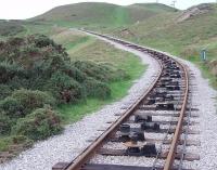 <I>Something missing?</I>. Winter on the upper section of the Great Orme Tramway and the tramcars are stored away and the looped haulage cable (one side for each car) has been removed. The cable rollers can clearly be seen in this view from the level crossing towards the summit. The vertical ones keep the cables between the rails on the curve.<br><br>[Mark Bartlett 30/11/2011]