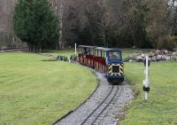 There are three miniature lines at the excellent Conwy Valley Railway Museum and this is the longest with two out and back loops making a circuit that takes ten minutes to complete. The line is fully signalled for an intensive summer service but only one train was required on 1st December. Diesel locomotive <I>Gwydir Castle</I> is seen here just crossing the bridge over the water feature with the Blaenau Ffestiniog branch in the background.<br><br>[Mark Bartlett 01/12/2011]