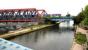 View west from Scrubs Lane towards Mitre Bridge over the Grand Union Canal in July 2005. The train is a Silverlink West London Line service from Clapham Junction to Willesden Junction which is about to bear left at Mitre Bridge Junction, following which it will cross over the WCML to reach the high level station [see image 5193]. Beyond the wall on the left are the various yards and rail facilities located around Old Oak Common. (The geese on the left gave me a bit of a hard time getting past!) <br><br>[John Furnevel 22/07/2005]