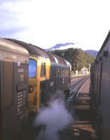 A Class 26 hauled Inverness-bound train ready for the off at Strathcarron in summer 1974 - although the offside door is hanging open on the photographer's train for some reason...!<br><br>[David Spaven //1974]