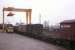 A typical scene at Elgin freight depot in the late 1970s - a BR lorry waits to offload a container of whisky casks for Central Scotland while a Class 24 draws a rake of conventional and container wagons into place under the depot's gantry crane.<br><br>[Frank Spaven Collection (Courtesy David Spaven) //]