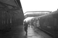 Passengers disembark from a Largs-bound train at West Kilbride on a cold and damp February day in 1963.<br><br>[R Sillitto/A Renfrew Collection (Courtesy Bruce McCartney) /02/1963]
