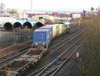 A class 66 locomotive shunting a container train from the W H Malcolm Grangemouth depot in January 2006. View is north towards the site of the former Grangemouth station, with Fouldubs Junction behind the camera. The chimney of Longannet power station, standing on the other side of the Forth, is prominent in the background.<br><br>[John Furnevel 24/01/2006]