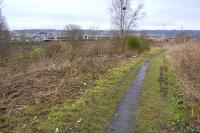 View looking north towards the site of the transfer point to the Fife Circle line from the former tramway running through Carden Den [see image 37588] with a ScotRail 170 passing.<br><br>[Bill Roberton 11/02/2012]
