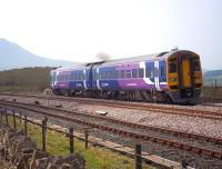 A Northern Rail service comprising unit 158855 leaves the single track section from Ribblehead Viaduct at Blea Moor Sidings on 18 April 2011, passing the semaphore signal which is just visible above the cab roof. Ingleborough dominates the left background. [See image 37951]<br><br>[Andrew Wilson 18/04/2011]