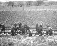 Another shot of the Permanent Way squad at work on Easter Sunday 1963 during the reballasting of Kilruskin cutting near West Kilbride [see image 37966]. Note the preferred headgear of the day.<br><br>[R Sillitto/A Renfrew Collection (Courtesy Bruce McCartney) 14/04/1963]