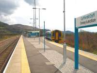 158828 stops briefly at Dovey Junction on the 8 min late 15.03 service to Pwllheli to (not) pick up the photographer who instead had to trek back to his vehicle parked beyond the river bridge at the far end of the 350 metre long Aberystwyth platform.<br><br>[David Pesterfield 13/04/2012]