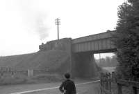 Scene at Andoversford in September 1962, the month before closure. A passing schoolboy stops to watch a pannier tank take a short freight east on the Kingham Branch.<br><br>[John Thorn /09/1962]