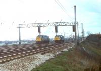 Two early Class 40s at the signal gantry to the south of Preston station in 1980. These signals control the reduction from six tracks to four and 40028, formerly <I>Samaria</I>, on the Up Goods line has been given the road ahead of 40010 once named <I>Empress of Britain</I>. 40028 only lasted another fifteen months in service before withdrawal from Kingmoor but 40010 continued until October 1984 when it was withdrawn from Longsight.  <br><br>[Mark Bartlett 08/04/1980]