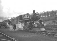 <I>The Stainmore Limited</I>, marking the end of operations over the South Durham and Lancashire Union Railway, stands at Kirkby Stephen East on 20 January 1962. The train is about to leave behind 77003+76049 on the return journey from Carlisle to Darlington via the 1,370 ft Stainmore Summit [see image 24103].<br><br>[K A Gray 20/01/1962]