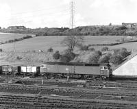 47301 leaves Healey Mills Yard with an eastbound empty colliery trip working in May 1977, overlooked by Ossett's rather austere looking late Victorian isolation hospital at the top of Storrs Hill.<br><br>[Bill Jamieson /05/1977]