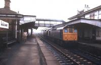 A pair of class 25 locomotives running through Gobowen station in March 1985.<br><br>[Ian Dinmore /03/1985]