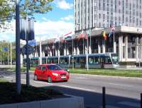 An Alstom Citadis tram on Grenoble's Line C route passes the 1968 Hotel de Ville (like the railway station, a 'legacy' building from the 1968 Winter Olympics) on Boulevard Jean Pain on a fine Sunday afternoon in April 2012.<br><br>[Andrew Wilson 29/04/2012]