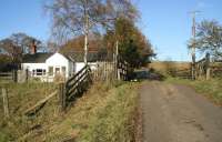 Approaching the level crossing at Thorneyburn station, between Kielder and Bellingham on the Border Counties Railway in November 2007. View is north with the platform remains off to the right. The former station house on the other side of the crossing is now a private residence. [See image 17646]<br><br>[John Furnevel 12/11/2007]