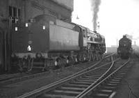Three years after official closure, Blackpool North shed plays host to Britannia Pacific no 70013 <I>Oliver Cromwell</I> of Carlisle Kingmoor, which had arrived in the town on Boxing Day 1967 with a football special. In the background is Stanier 8F 2-8-0 no 48033. Final demolition took place here in 1975.<br><br>[K A Gray 26/12/1967]