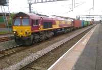 66041 and its containers make a colourful sight at Nuneaton on 29 June as the train snakes between the platform 4 through route and platform 1 (Coventry line). At least one down passenger train was slowed to allow this relatively rare conflicting movement.<br><br>[Ken Strachan 29/06/2012]
