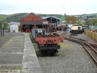 The Vale of Rheidol Railway's old Aberystwyth steam shed seen beyond the former bay platform end in May 2012, with the new VoR platform line and run round loop on the right. The new stabling and heavy maintenance facility can be seen under construction beyond the rear of the steam shed. Nearest the camera on the flat wagon is the main frame for VoR No7 Owain Glyndwr which is awaiting completion of the new facility to allow rebuilding to be started.<br><br>[David Pesterfield 10/05/2012]