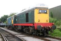 A pair of EE Type 1s stabled in the sidings at the Wensleydale Railway's Leeming depot on 9 July 2012. Nearest the camera is green liveried 20166, with sister locomotive 20121 in BR blue beyond.<br><br>[John Furnevel 09/07/2012]