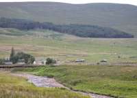 158702 approaches the station at Achnasheen on 7th July on a service for Kyle. There is a passing loop here and both platforms are in use. In the foreground the bed of the River Bran can be seen, evidence of the prolonged dry weather in NW Scotland in 2012. <br><br>[Mark Bartlett 07/07/2012]