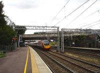 A recent build 11 car Virgin Pendolino races south through Lichfield Trent Valley Low Level station on 31 July. Up above, a London Midland 323 EMU is about to depart the High Level platform on the 12.50 service to Longbridge. <br><br>[David Pesterfield 31/07/2012]